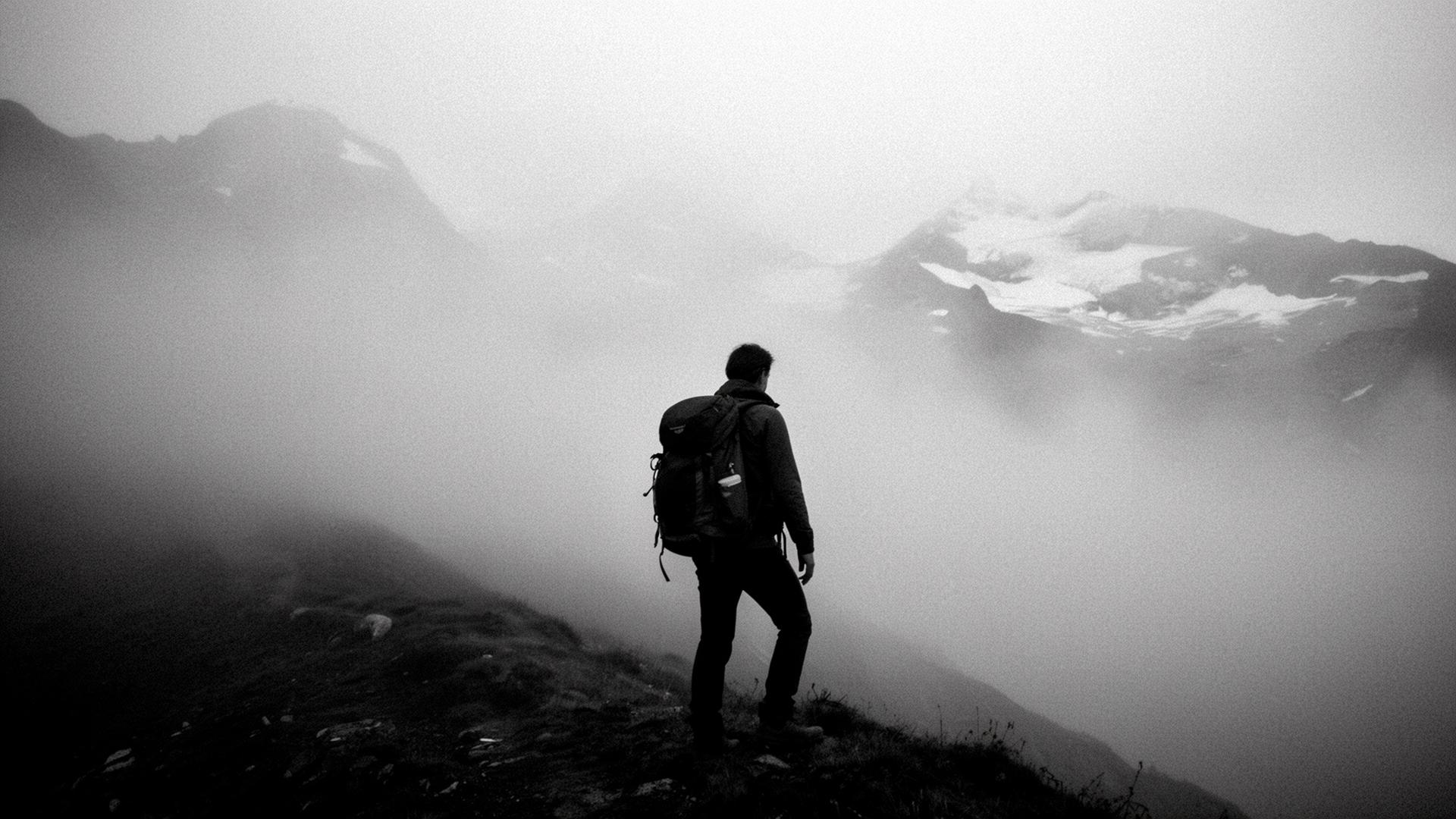 Einzelner Wanderer im dichten Bergnebel, Sicht auf das Ziel verloren